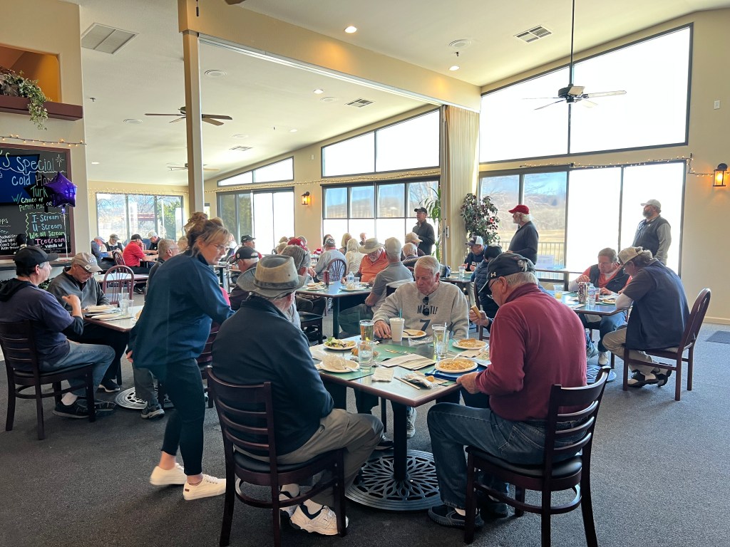Senior diners enjoying a meal at the restaurant on a sunny day.